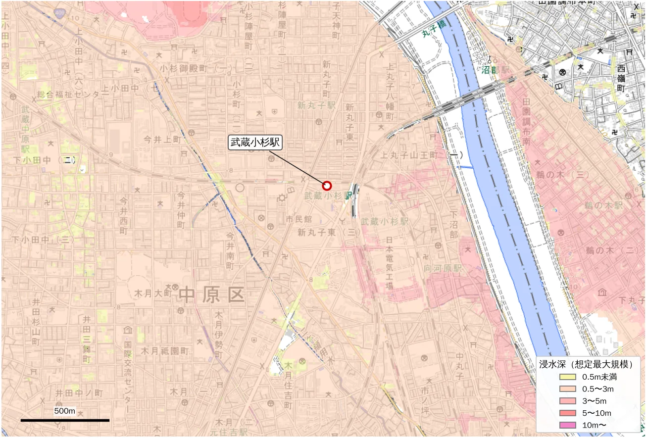 A pale map of the Musashi-Kosugi area with the national flood inundation assumptions (maximum scale) overlaid. A wide area including the station is painted pale orange (0.5 to 3 m). Parts along the Tama levee and near Unoki on the opposite bank are a slightly deeper pink (3 to 5 m). Much of the upland across the river is uncolored