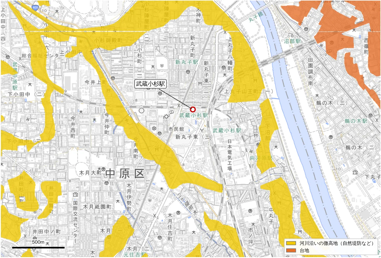 A pale map of the Musashi-Kosugi area with Land Condition Map classes overlaid. A yellow band winds from Kosugi-Gotenmachi toward Imai and Kizuki, running northwest to southeast, and the station lies just east of that band. Orange upland appears across the Tama River in the upper right